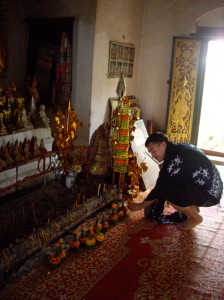 Scott setting down an offering at the Buddhist temple on the hilltop in Luang Prabang