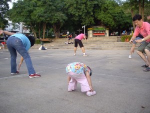 A little 2-yr old girl doing aerobics in the park
